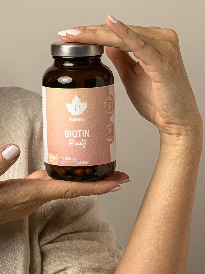 En kvinnas händer som håller i en burk biotin beauty