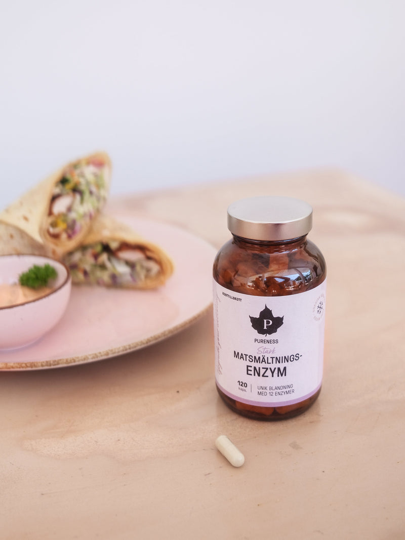 en burk matsmältningsenzym som står på ett bord med en tallrik burritos bakom