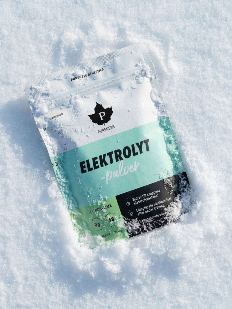 en påse pureness elektrolytpulver citron lime som ligger i snön
