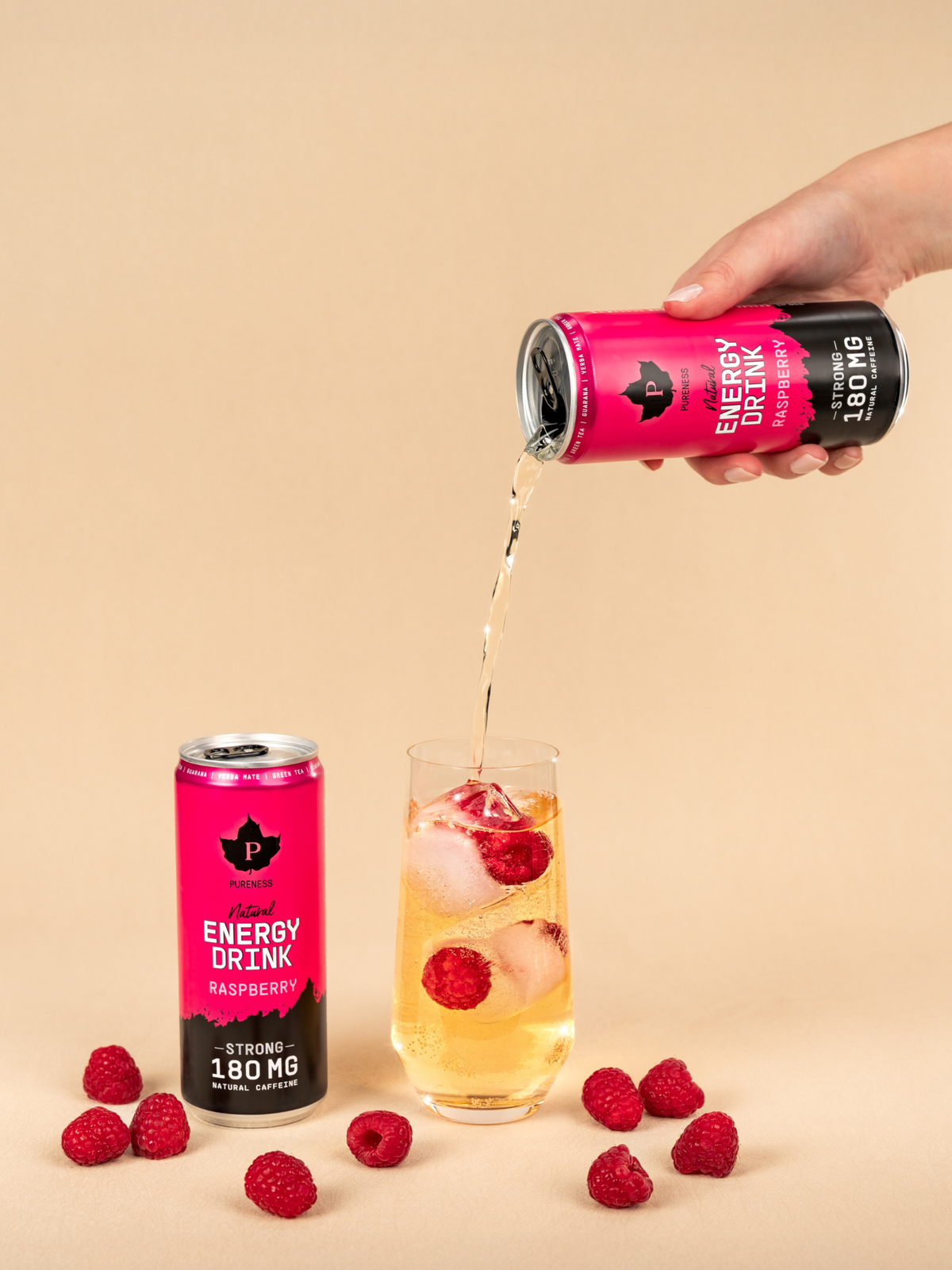 två burkar pureness energy drink hallon varav en hälls upp i ett glas