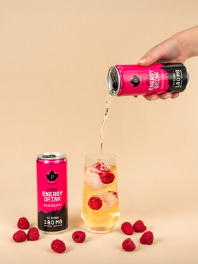 två burkar pureness energy drink hallon varav en hälls upp i ett glas