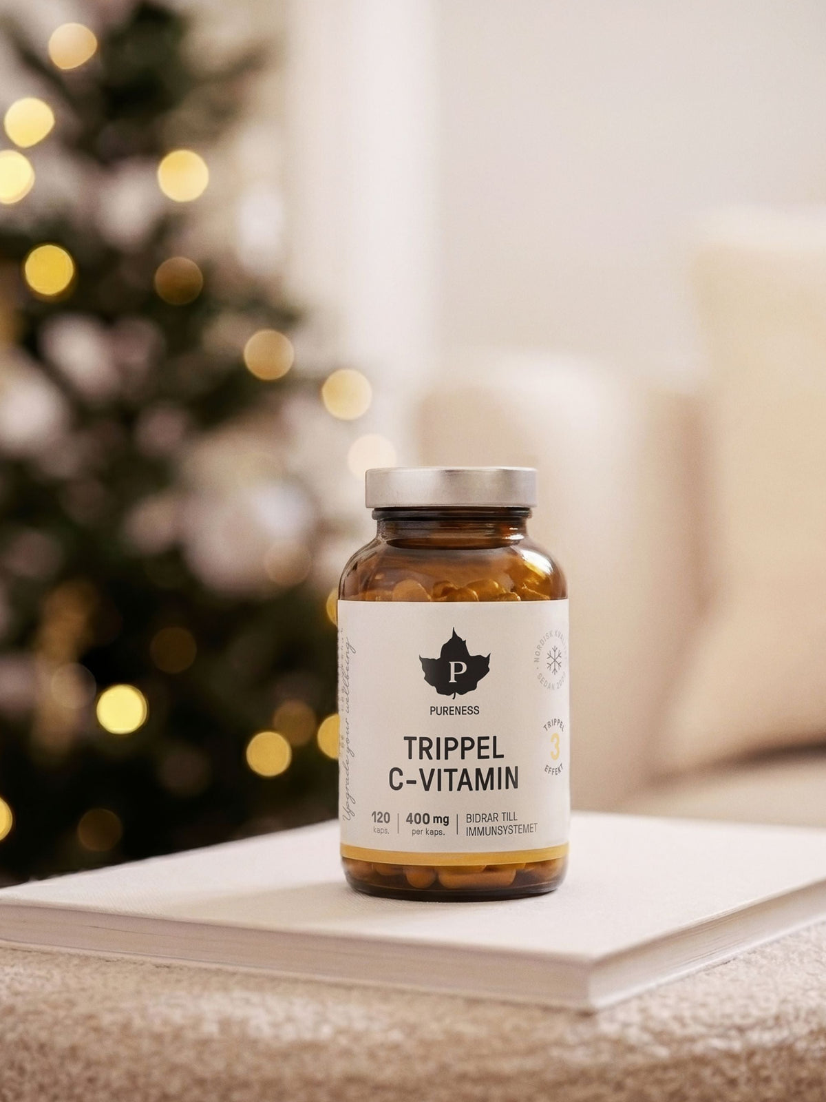 en burk pureness trippel c-vitamin som står på en soffa med en julgran i bakgrunden