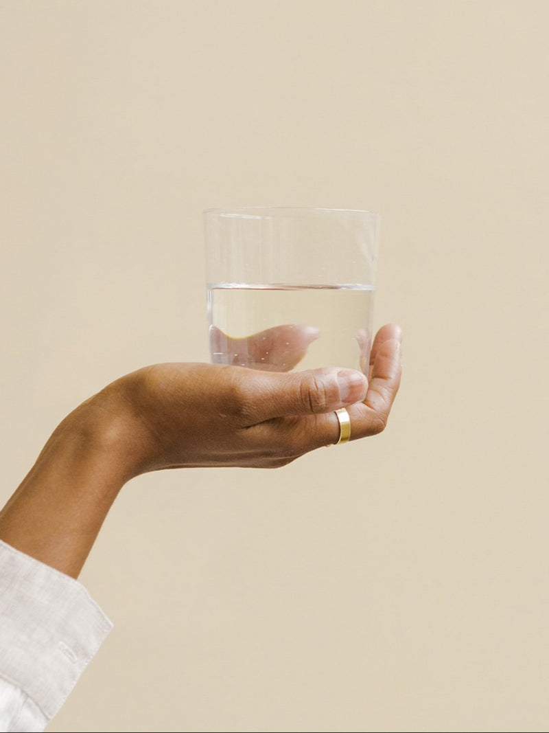 en hand som håller i ett glas vatten