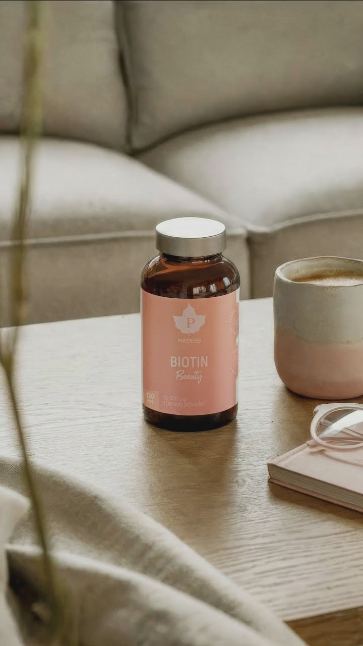 En video på en kvinna som plockar upp en burk biotin beauty från ett soffbord